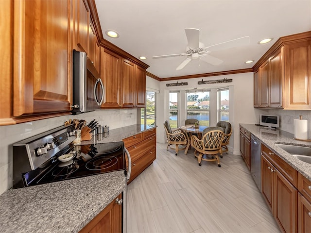 kitchen with stainless steel appliances, tasteful backsplash, light stone countertops, and crown molding