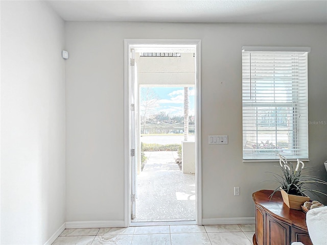 doorway featuring light tile patterned flooring and a healthy amount of sunlight