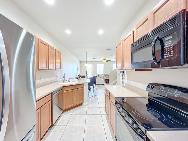 kitchen with sink, decorative light fixtures, light tile patterned floors, kitchen peninsula, and black appliances