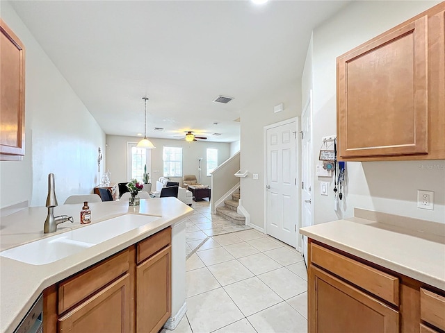 kitchen with light tile patterned flooring, sink, hanging light fixtures, dishwashing machine, and ceiling fan