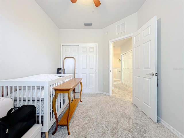 bedroom with ceiling fan, light colored carpet, and a closet