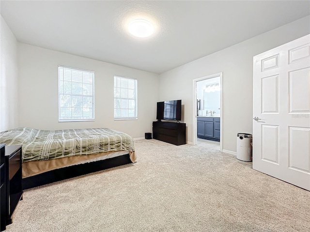 carpeted bedroom featuring ensuite bath