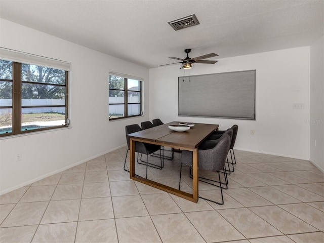 dining room featuring light tile patterned floors, a textured ceiling, and ceiling fan