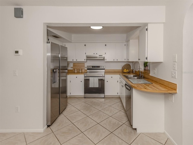 kitchen with sink, light tile patterned floors, white cabinetry, stainless steel appliances, and kitchen peninsula