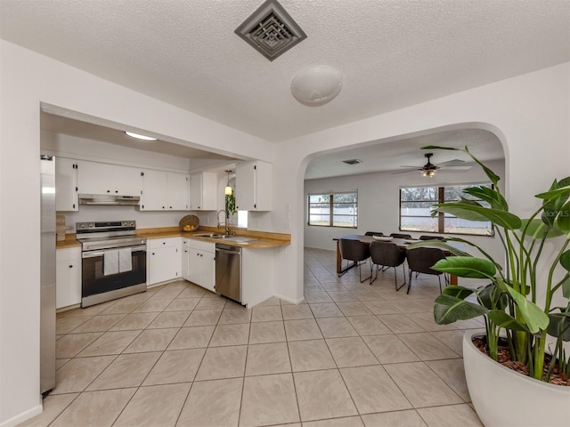 kitchen featuring light tile patterned flooring, appliances with stainless steel finishes, sink, white cabinets, and ceiling fan