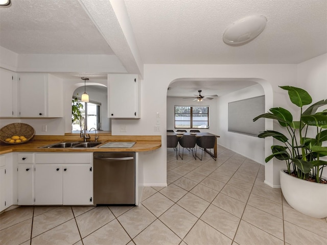 kitchen featuring butcher block countertops, dishwasher, white cabinetry, sink, and hanging light fixtures