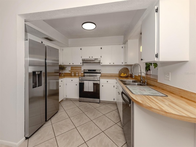 kitchen with light tile patterned floors, appliances with stainless steel finishes, sink, and white cabinets