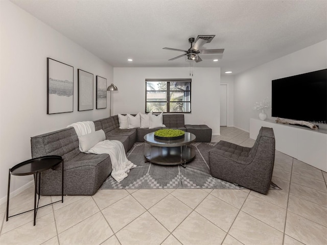 living room featuring ceiling fan, a textured ceiling, and light tile patterned floors