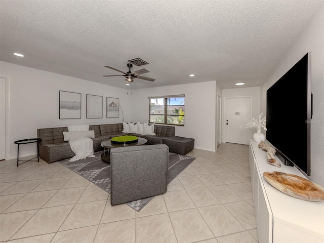 tiled living room featuring ceiling fan and a textured ceiling