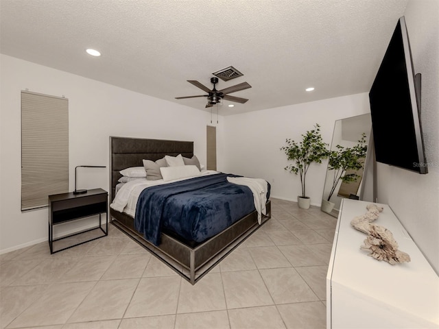 tiled bedroom with ceiling fan and a textured ceiling