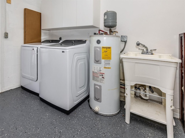 clothes washing area with washer and dryer, cabinets, and water heater