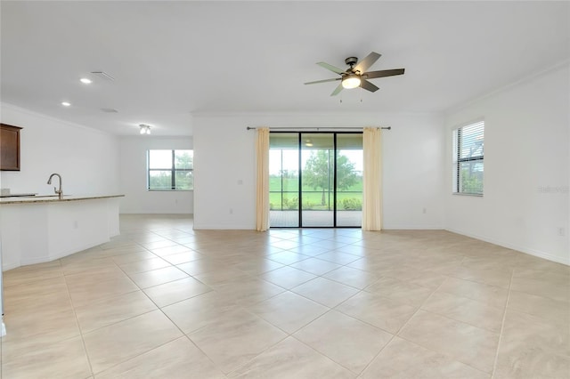 empty room with crown molding, ceiling fan, light tile patterned flooring, and sink