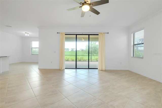 empty room with crown molding, ceiling fan, and light tile patterned floors