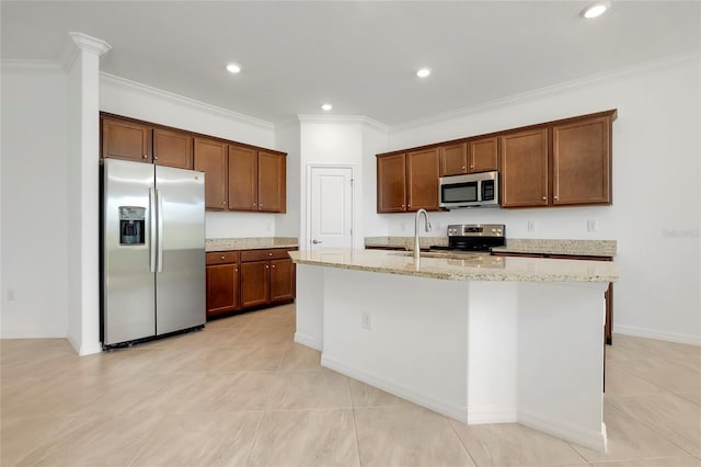 kitchen featuring sink, stainless steel appliances, light stone counters, ornamental molding, and a center island with sink