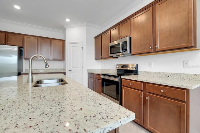 kitchen featuring ornamental molding, appliances with stainless steel finishes, light stone countertops, and sink