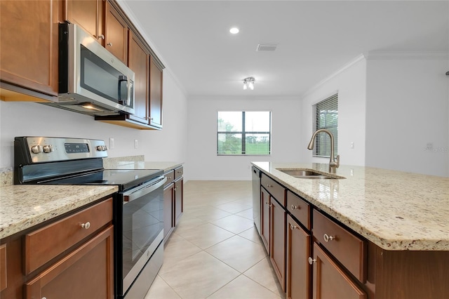 kitchen featuring light stone counters, ornamental molding, appliances with stainless steel finishes, and sink