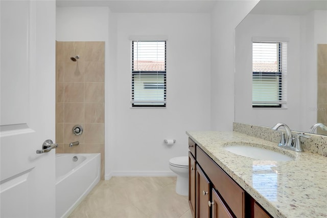 full bathroom featuring tile patterned flooring, vanity, tiled shower / bath, and toilet