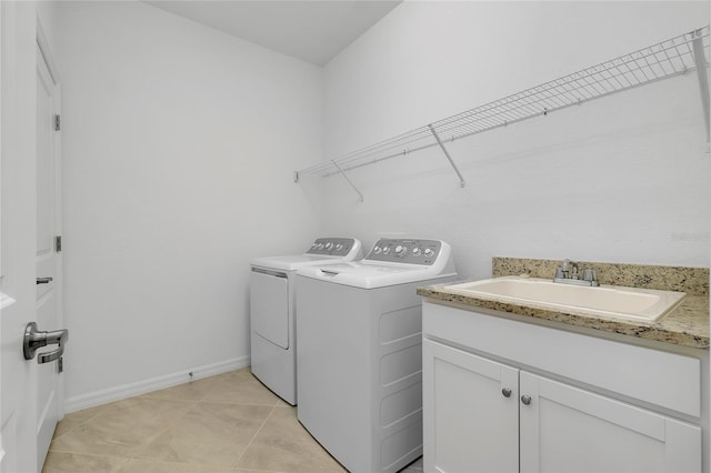 laundry room with sink, light tile patterned floors, cabinets, and washing machine and clothes dryer