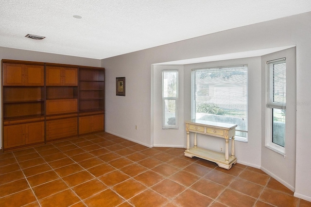 doorway to outside featuring tile patterned flooring and a textured ceiling