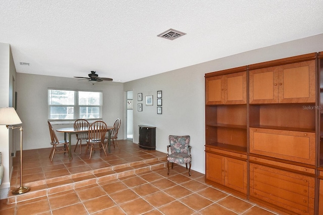 dining room with ceiling fan, visible vents, a textured ceiling, and light tile patterned flooring