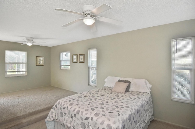 carpeted bedroom with a ceiling fan and a textured ceiling