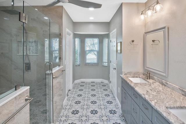 bathroom with a sink, baseboards, tile patterned floors, double vanity, and a stall shower