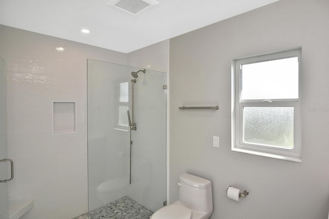 bathroom featuring toilet, a shower stall, and visible vents