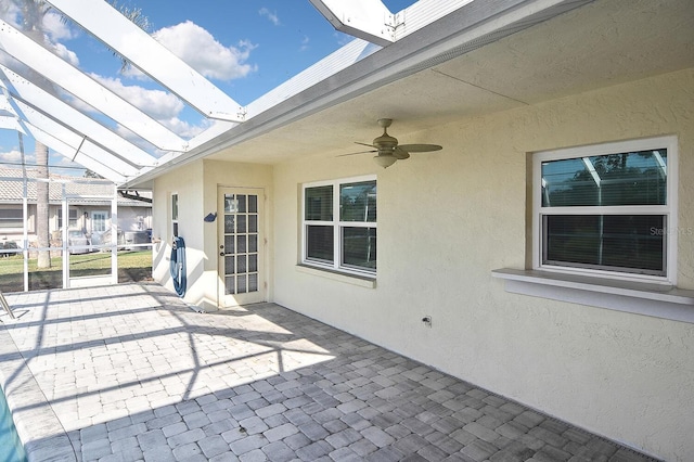 view of patio / terrace featuring glass enclosure and ceiling fan