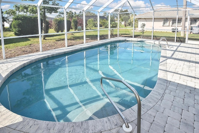 view of swimming pool with glass enclosure and a patio area