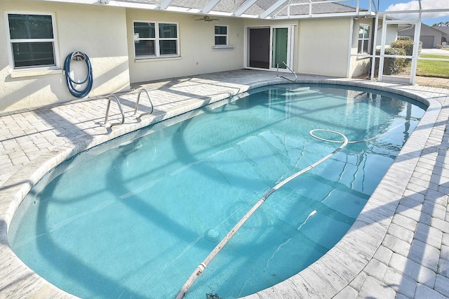 view of pool with a patio and glass enclosure