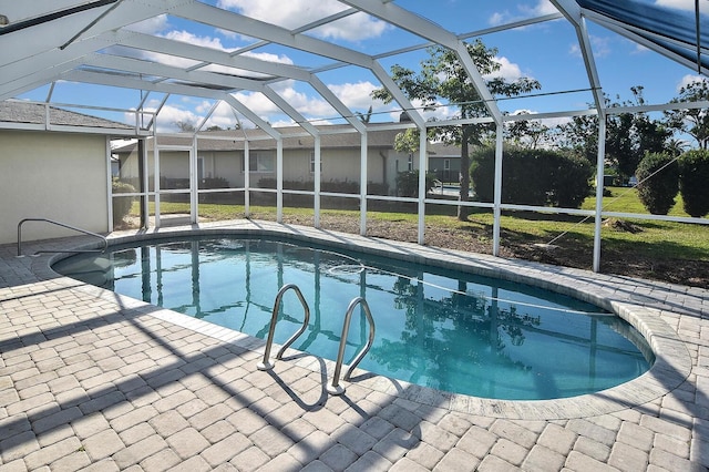 view of pool with a yard, a patio, and glass enclosure