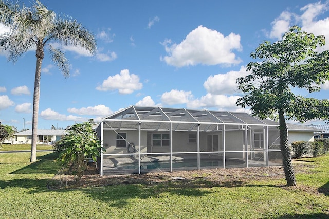 rear view of property with a yard and a lanai