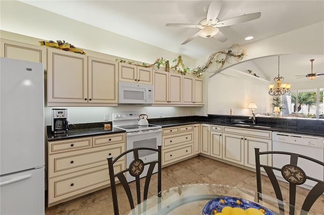 kitchen with dark countertops, white appliances, and cream cabinets