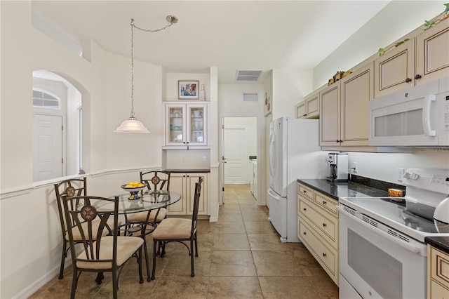 kitchen featuring hanging light fixtures, white appliances, cream cabinets, and light tile patterned floors