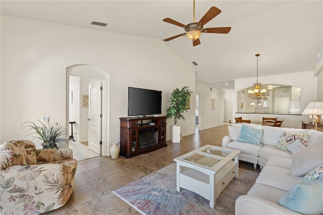 living room with ceiling fan with notable chandelier, light tile patterned flooring, and high vaulted ceiling