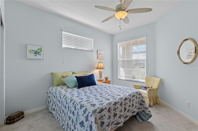 bedroom with a ceiling fan, light colored carpet, and baseboards