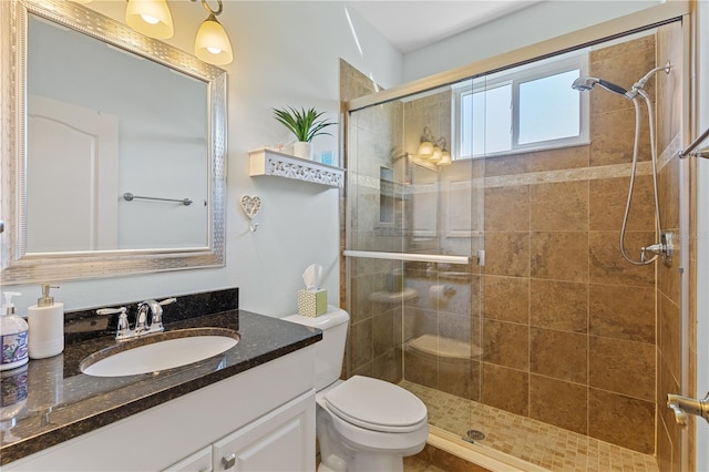 bathroom featuring a tile shower, vanity, and toilet