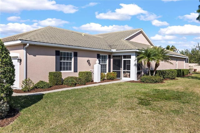 view of front of house featuring a sunroom and a front lawn