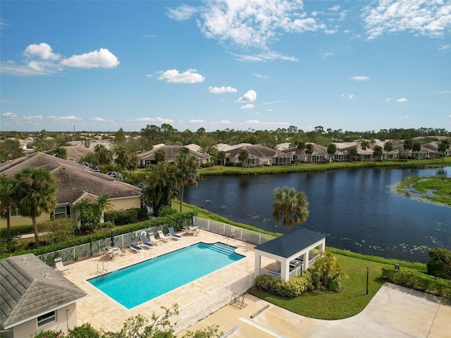 pool with a water view, a residential view, fence, and a patio