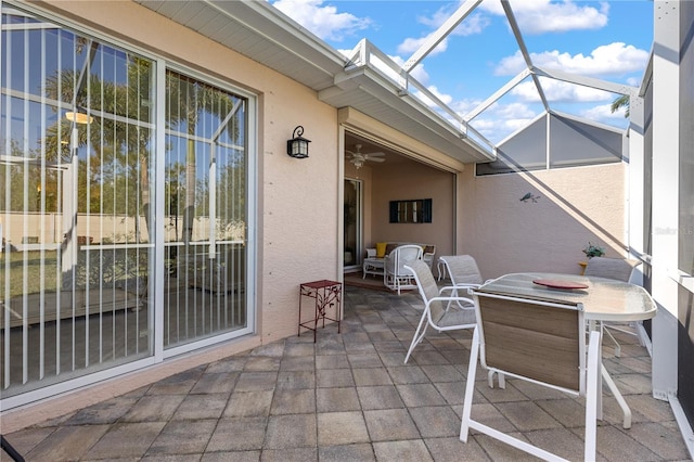 view of patio with glass enclosure and ceiling fan