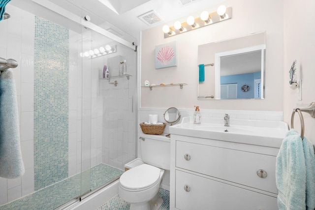 bathroom with vanity, a shower with shower door, and toilet