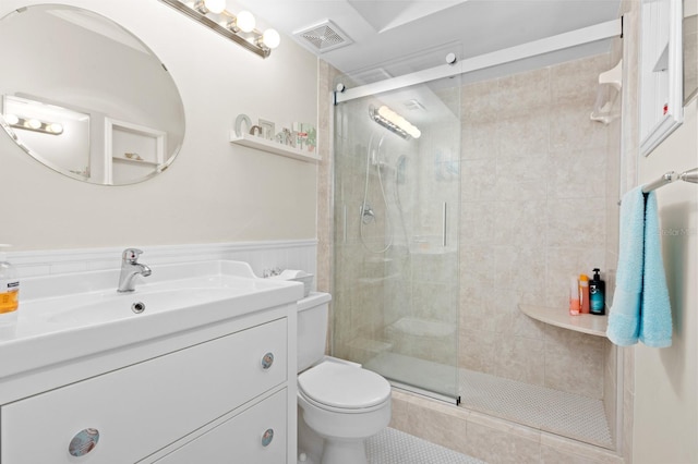 bathroom with vanity, toilet, and a shower with shower door