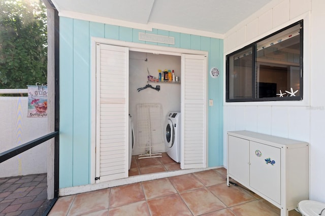 clothes washing area with light tile patterned floors