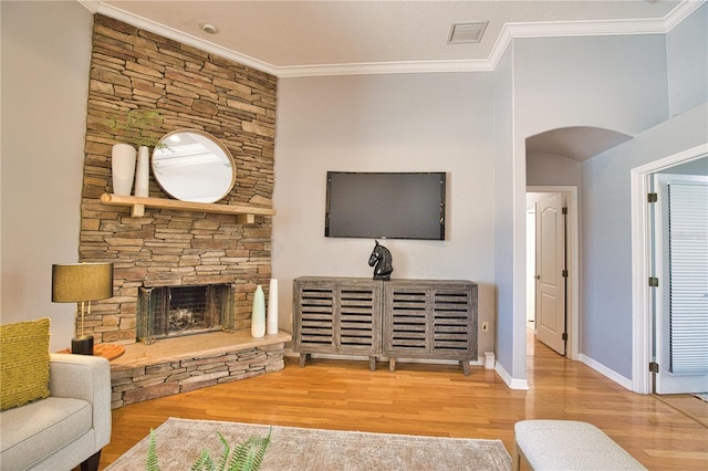 living room featuring hardwood / wood-style flooring, a fireplace, and ornamental molding