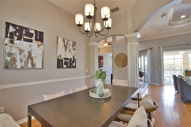 dining room featuring crown molding, light hardwood / wood-style flooring, ceiling fan, and ornate columns