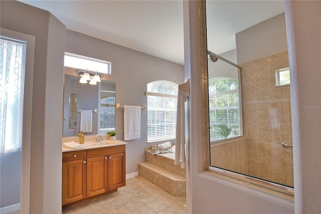 bathroom featuring vanity, tile patterned floors, a textured ceiling, and a tile shower