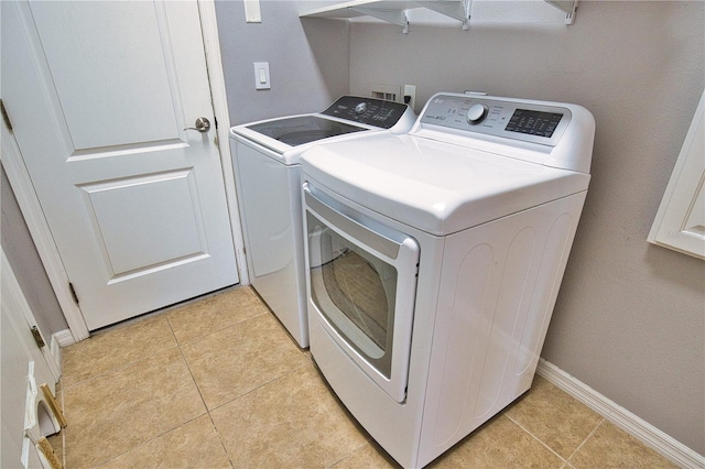 washroom featuring washing machine and clothes dryer and light tile patterned floors