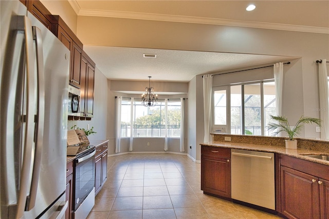 kitchen with stainless steel appliances, hanging light fixtures, light tile patterned floors, and light stone counters