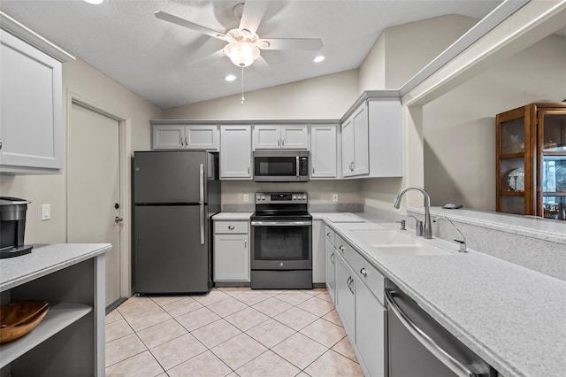 kitchen featuring lofted ceiling, ceiling fan, appliances with stainless steel finishes, light countertops, and a sink