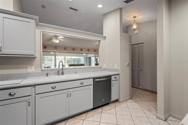 kitchen with visible vents, dishwasher, light countertops, a sink, and light tile patterned flooring